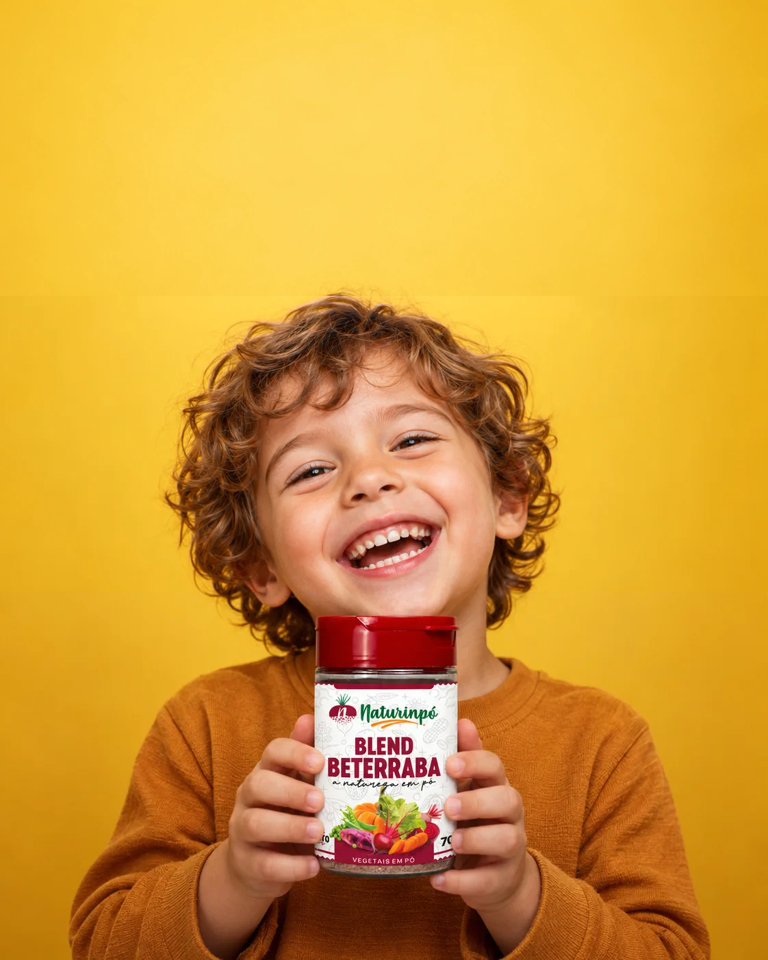 Criança sorrindo enquanto segura um pote do blend de beterraba Naturinpó